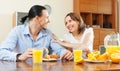 Happy couple having breakfast with scrambled eggs and oranges