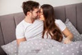 Happy couple having fun in bed. Intimate sensual young couple in bedroom enjoying each other