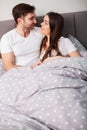 Happy couple having fun in bed.Young couple in bedroom enjoying each other.