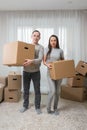 Happy couple having fun with cardboard boxes in new house on moving day Royalty Free Stock Photo