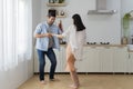 Happy couple having fun in the kitchen dancing together celebrating immigration or anniversary handsome young husband holding Royalty Free Stock Photo