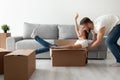 Happy couple having fun playing with cardboard box moving in