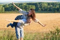 Happy couple having fun on outdoor, girl riding on man back and fly - romantic travel and people concept, summer landscape with Royalty Free Stock Photo