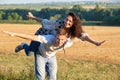Happy couple having fun on outdoor, girl riding on man back and fly - romantic travel and people concept, summer landscape with Royalty Free Stock Photo