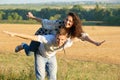 Happy couple having fun on outdoor, girl riding on man back and fly - romantic travel and people concept, summer landscape with Royalty Free Stock Photo