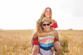Happy Couple Having Fun Outdoors on wheat field. Freedom Concept. Piggyback Royalty Free Stock Photo