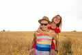 Happy Couple Having Fun Outdoors on wheat field. Freedom Concept. Piggyback Royalty Free Stock Photo