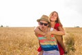 Happy Couple Having Fun Outdoors on wheat field. Laughing Joyful Family together. Freedom Concept. Piggyback Royalty Free Stock Photo