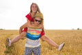 Happy Couple Having Fun Outdoors on wheat field. Laughing Joyful Family together. Freedom Concept. Piggyback Royalty Free Stock Photo