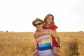 Happy Couple Having Fun Outdoors on wheat field. Laughing Joyful Family together. Freedom Concept. Piggyback Royalty Free Stock Photo