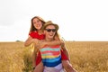 Happy Couple Having Fun Outdoors on wheat field. Laughing Joyful Family together. Freedom Concept. Piggyback Royalty Free Stock Photo