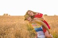 Happy Couple Having Fun Outdoors on wheat field. Laughing Joyful Family together. Freedom Concept. Piggyback Royalty Free Stock Photo