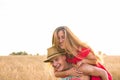 Happy Couple Having Fun Outdoors on wheat field over sunset. Laughing Joyful Family together. Freedom Concept. Piggyback Royalty Free Stock Photo