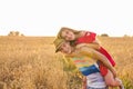 Happy Couple Having Fun Outdoors on wheat field over sunset. Laughing Joyful Family together. Freedom Concept. Piggyback Royalty Free Stock Photo