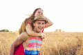 Happy Couple Having Fun Outdoors on wheat field over sunset. Laughing Joyful Family together. Freedom Concept. Piggyback Royalty Free Stock Photo