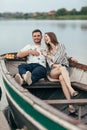 Happy Couple Having Fun Relaxing In Boat On Lake