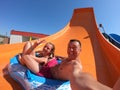 Happy couple having fun in water slides. Amusement, aqua Royalty Free Stock Photo