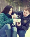 Happy couple having fun in the winter park drinking hot tea Royalty Free Stock Photo