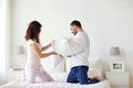 Happy couple having pillow fight in bed at home Royalty Free Stock Photo