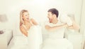 Happy couple having pillow fight in bed at home Royalty Free Stock Photo