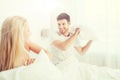 Happy couple having pillow fight in bed at home Royalty Free Stock Photo