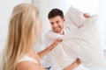 Happy couple having pillow fight in bed at home Royalty Free Stock Photo