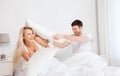 Happy couple having pillow fight in bed at home Royalty Free Stock Photo