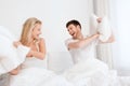 Happy couple having pillow fight in bed at home Royalty Free Stock Photo