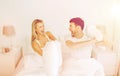 Happy couple having pillow fight in bed at home Royalty Free Stock Photo