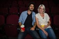 Couple having popcorn while watching movie in theatre Royalty Free Stock Photo