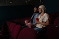 Couple having popcorn while watching movie in theatre Royalty Free Stock Photo