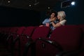 Couple having popcorn while watching movie in theatre Royalty Free Stock Photo