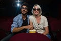 Couple having popcorn while watching movie in theatre Royalty Free Stock Photo