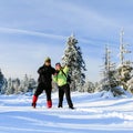 Happy couple hiking on snow trail in winter mountains Royalty Free Stock Photo