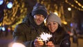 Cute young couple holding sparklers