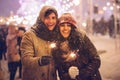 Happy Couple Holding Bengal Lights Standing Outdoor At Night