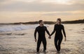 Happy Couple Holding Hands While Walking On The Beach Together Royalty Free Stock Photo