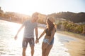 Happy couple holding hands walking at coast laughing Royalty Free Stock Photo