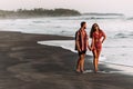 Happy couple holding hands walking on the sandy beach. Couple in love at sunset by the sea. Couple in love on vacation. Honeymoon Royalty Free Stock Photo