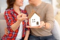 Happy couple holding keys to new home and house miniature - real Royalty Free Stock Photo