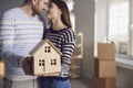 Happy couple holding a model of the house in the hands of the new room apartment house. Royalty Free Stock Photo