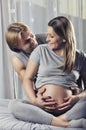 Happy couple holding pregnant belly and smile Royalty Free Stock Photo