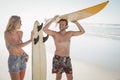 Happy couple holding surfboard at beach Royalty Free Stock Photo