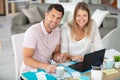 happy couple at home paying bills with laptop Royalty Free Stock Photo