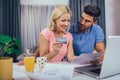 Couple at home paying bills with laptop and credit card Royalty Free Stock Photo