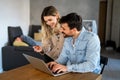 Happy couple at home paying bills or online shopping with laptop and credit card Royalty Free Stock Photo