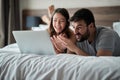 Happy couple at home surfing the net in bed Royalty Free Stock Photo