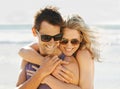 Happy couple, hug and sunglasses at beach with sunshine for summer vacation, honeymoon and traveling. Man, smile and Royalty Free Stock Photo