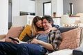 Happy, couple and hug for watching tv in home, cable movies and news show of film media in lounge. Mature man, woman and