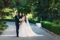 Happy couple hugging and hanging out in the park. The bride in a black suit with a bow tie and a bride in a beautiful Royalty Free Stock Photo